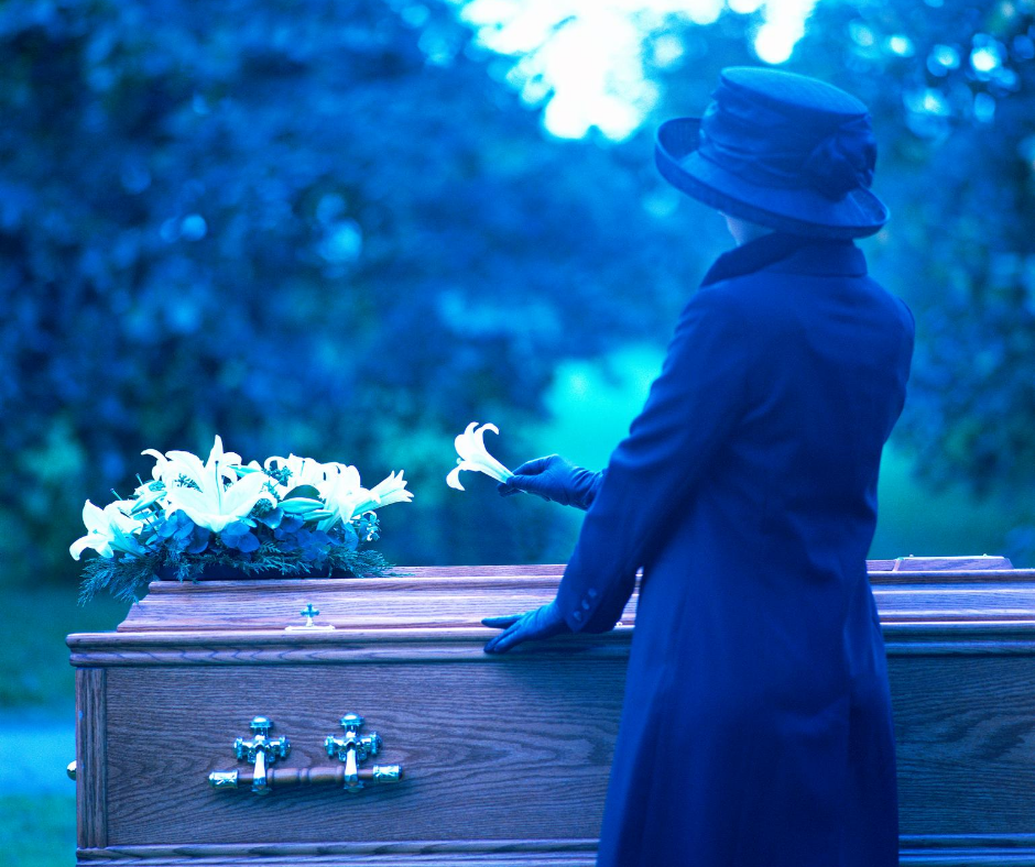 woman placing a flower on a casket | funeral planning faq | Overnight Caskets