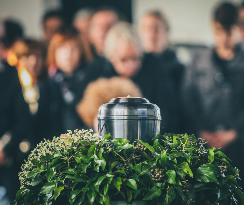 Urn in foreground, mourning family in background | Burial vs. cremation | Overnight Caskets